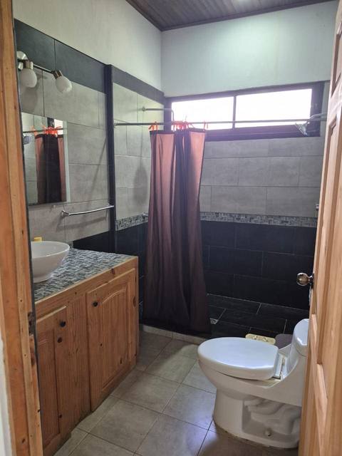 Baño con tina tipo jacuzzi y cortina en tono terracota