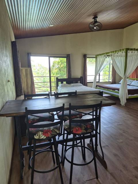 Sala-comedor amplia con techo de madera y salida al balcón