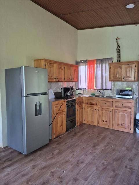 Cocina totalmente equipada con refrigeradora, estufa y gabinetes de madera