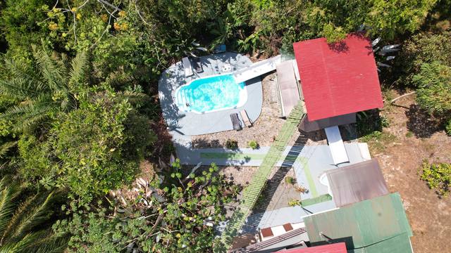 Vista aérea de la piscina, el tobogán y el puente de canopy entre techos de colores