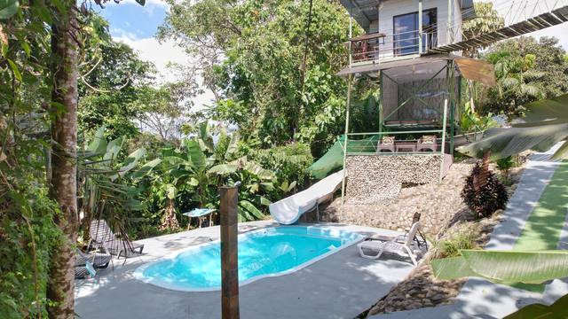 Vista aérea de la piscina y la cabaña elevada junto al puente colgante
