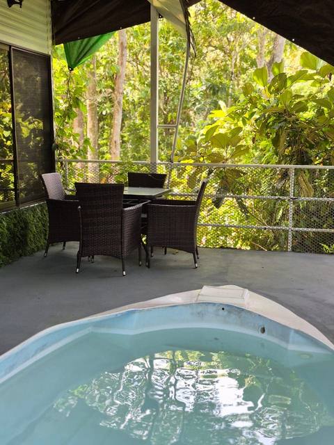 Terraza privada con mesa para comer y piscina propia asomada al bosque