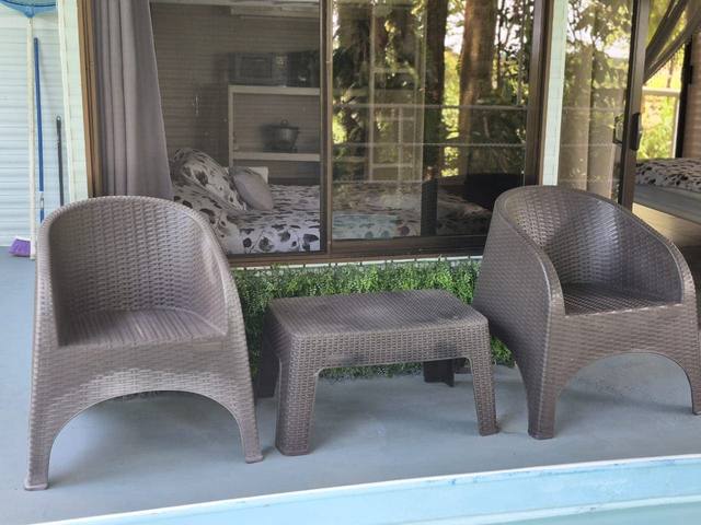 Sillones junto al ventanal, con el bosque reflejado en la piscina