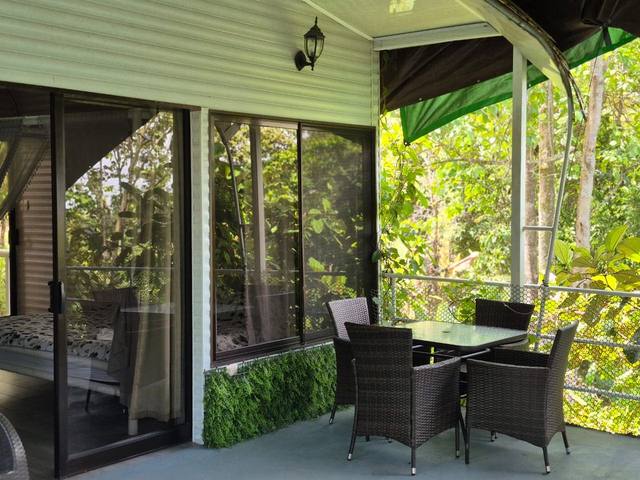 Terraza techada con mesa para comer en medio del dosel de la selva