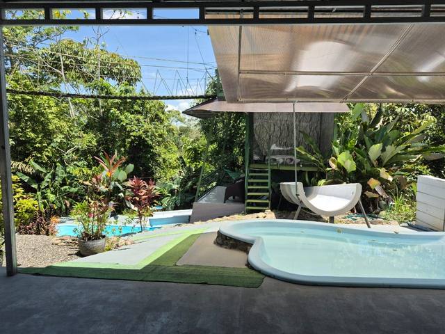 Piscina común bajo el puente de canopy, junto al tobogán y la cabaña elevada